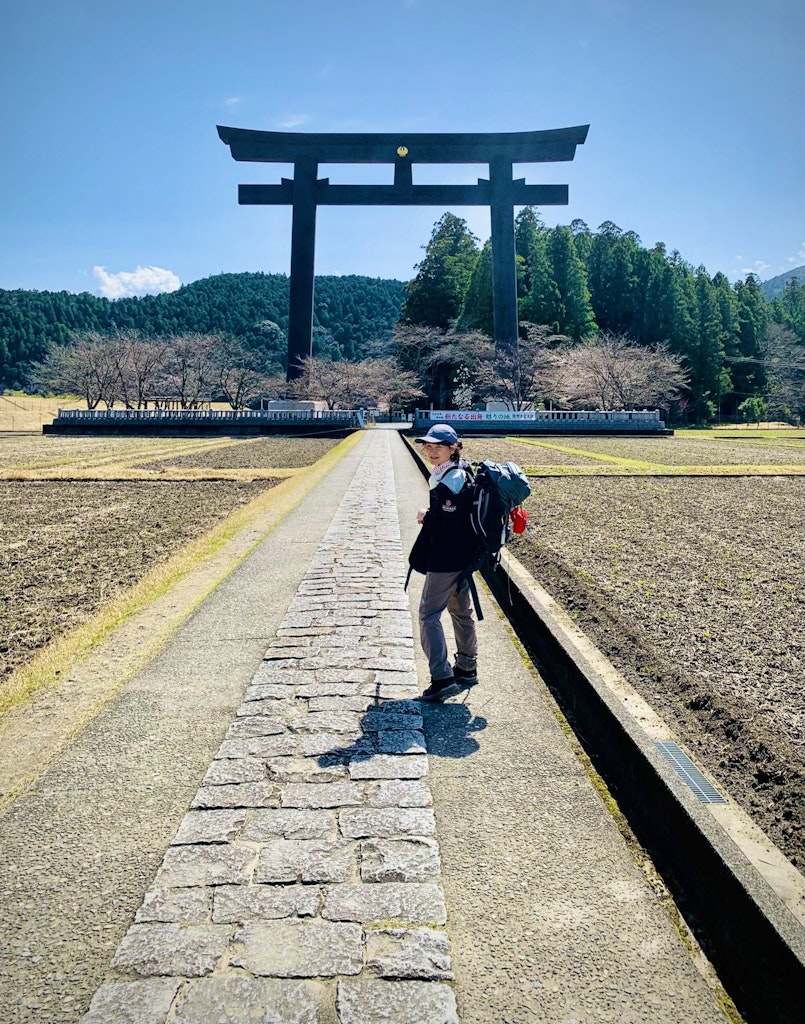 Traveler exploring the original Hongu Taisha Shrine in Oyunohara - home to the world's largest Torri gate