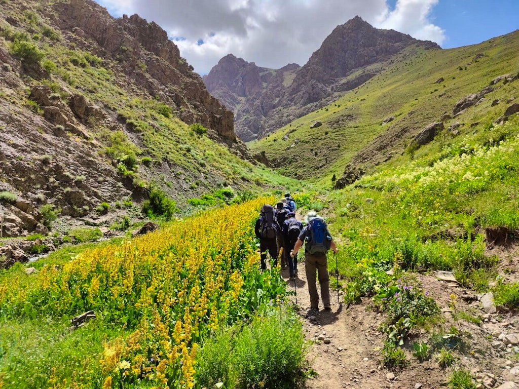 Hikers descending on an off the beaten trail in the Tajikistan Fann Mountains