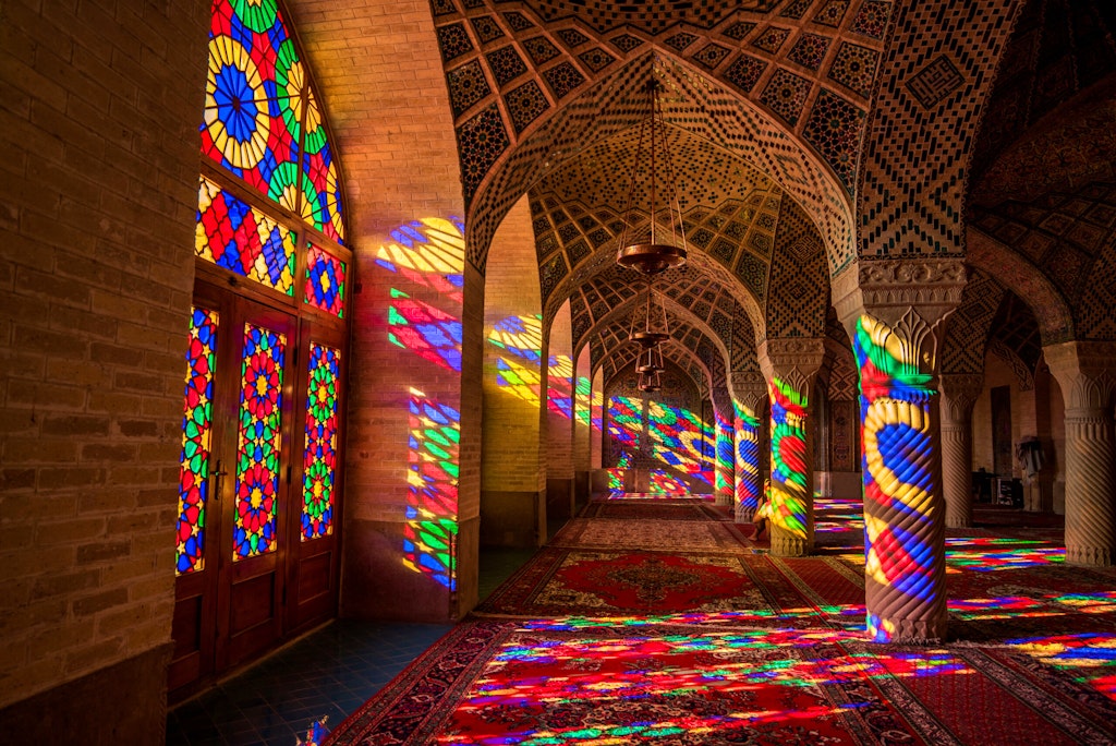 Colorful light through stained glass window inside Nasir Al-Mulk Mosque, a traditional mosque in Shiraz, Iran. 