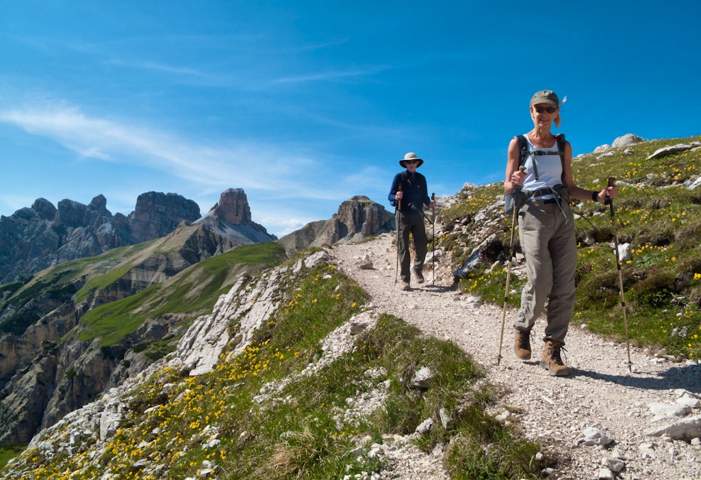 Travelers hiking on a trail along the Dolomite's dramatic, craggy mountains - a hiker's dream