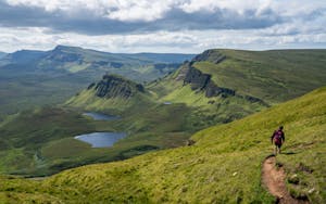 Hiker trekking the great green landscape of Scotland Western Isles