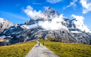 Couple man and woman hiking a hiking trail using the Haute Route in the Alps region in Switzerland, Europe