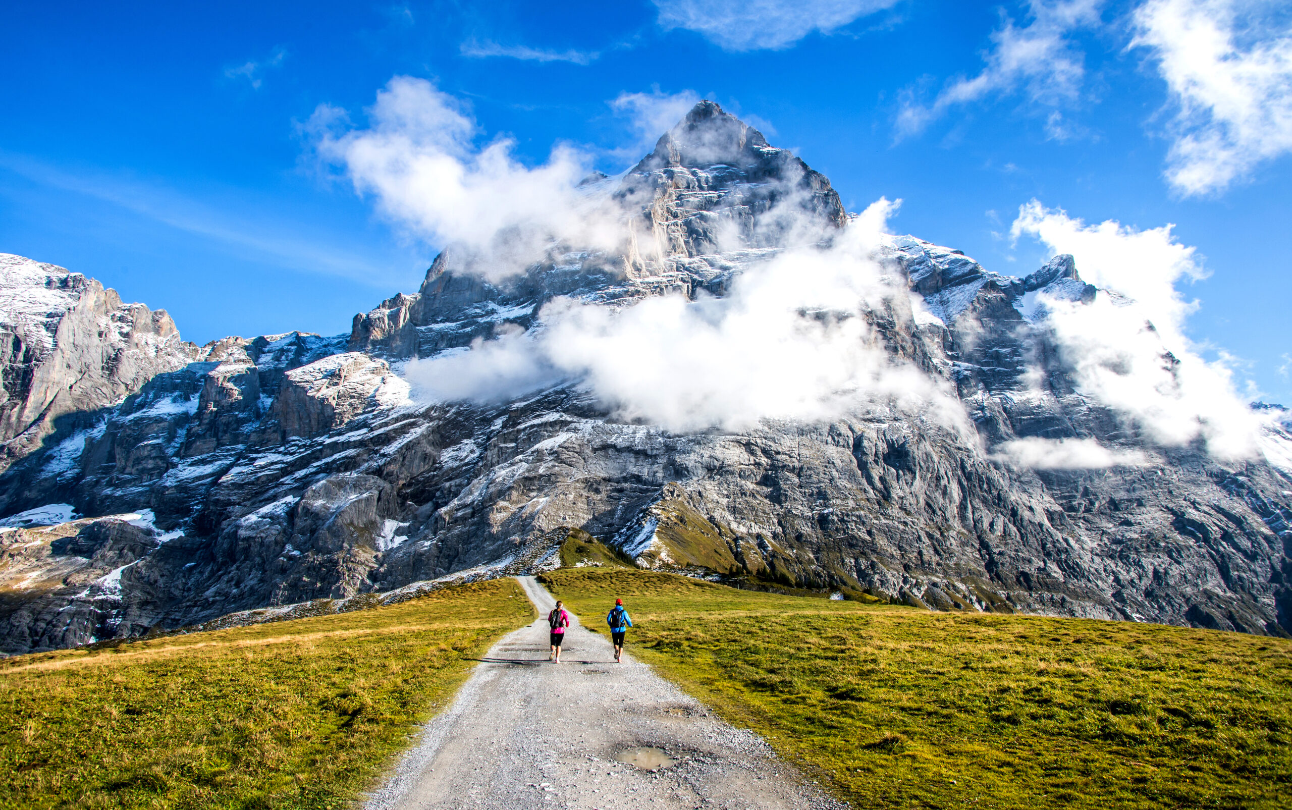 Couple man and woman hiking a hiking trail using the Haute Route in the Alps region in Switzerland, Europe