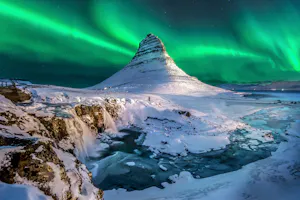 An aurora bore over a mountain in iceland.