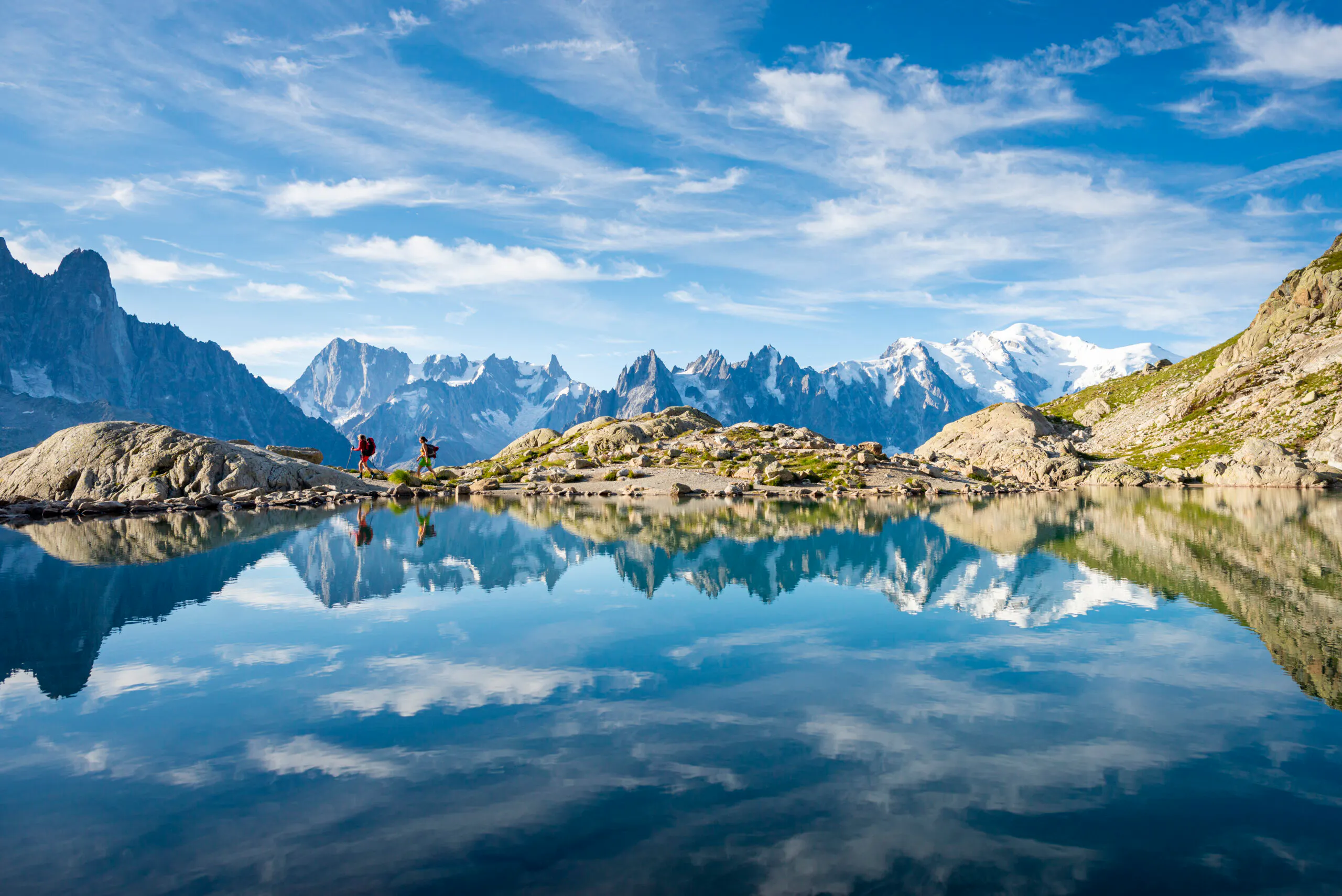 The white snowy topped domed shape summit of Mont Blanc is the highest peak on the right side