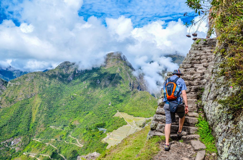 Male Tourist climbing Huayna Picchu mountain for one of the best panoramic views of Machu Picchu