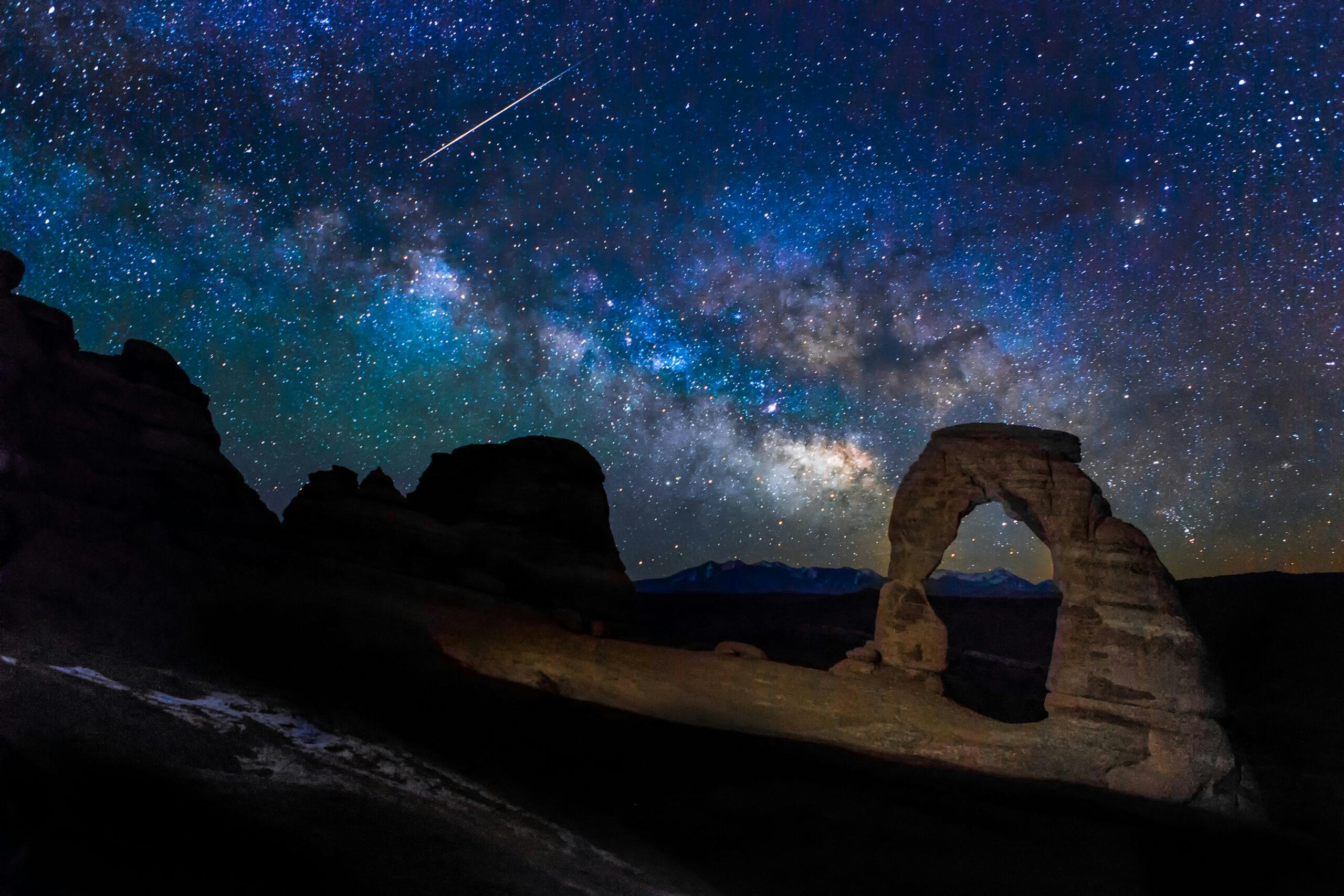 Night photography showing meteor and milky way near Delicate Arch in Moab, Utah