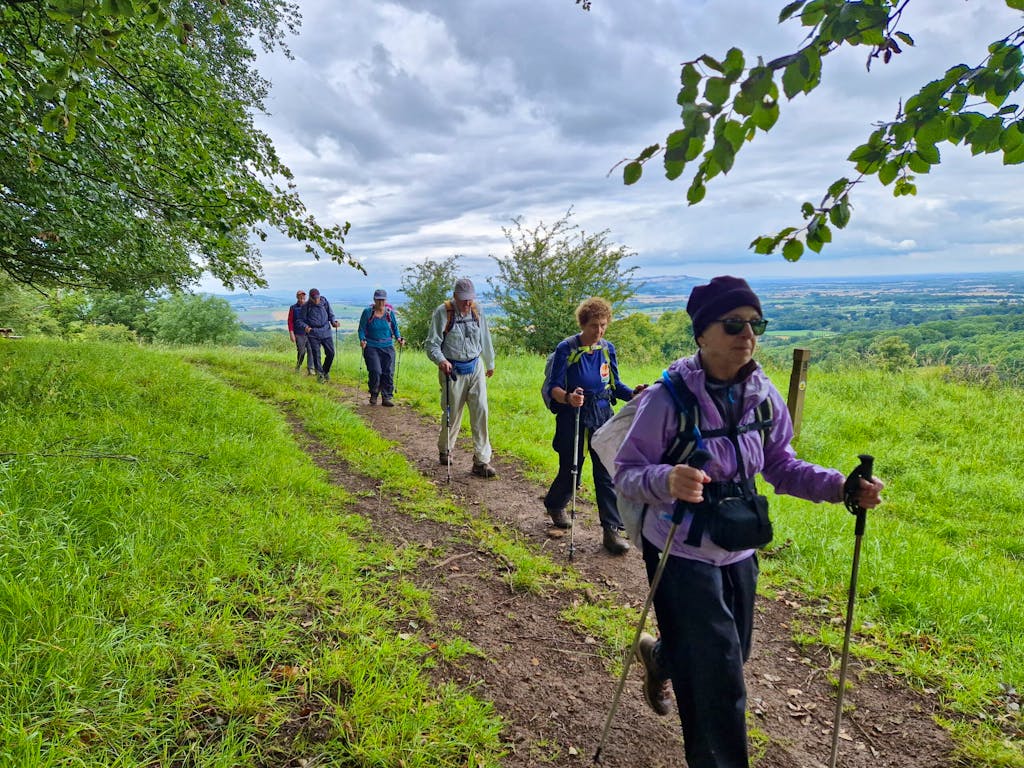 group of female and male hikers walking along trail in England, Europe