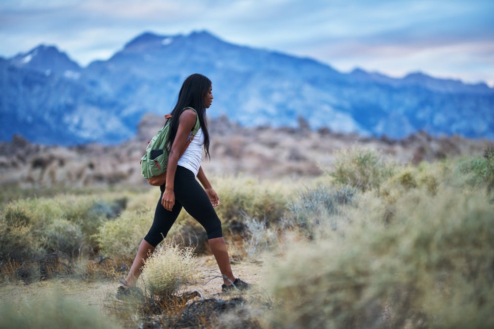 solo female hiker hiking the desert oasis of Joshua Tree National Park