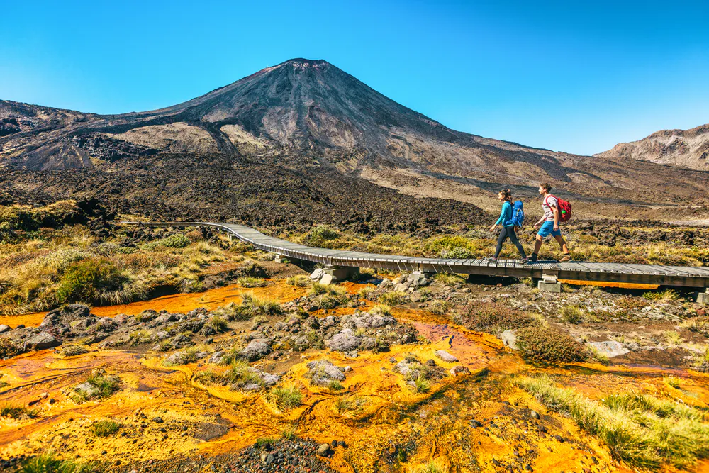 female and male hikers hiking through Tongariro Alpine Circuit, a must do when visiting New Zealand!