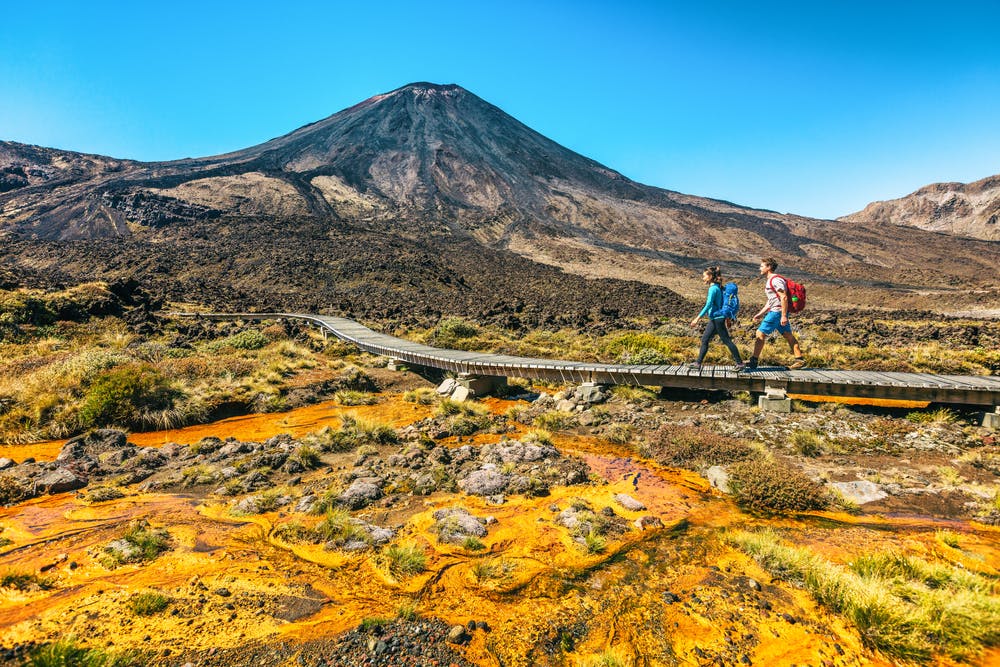 female and male hikers hiking through Tongariro Alpine Circuit, a must do when visiting New Zealand!