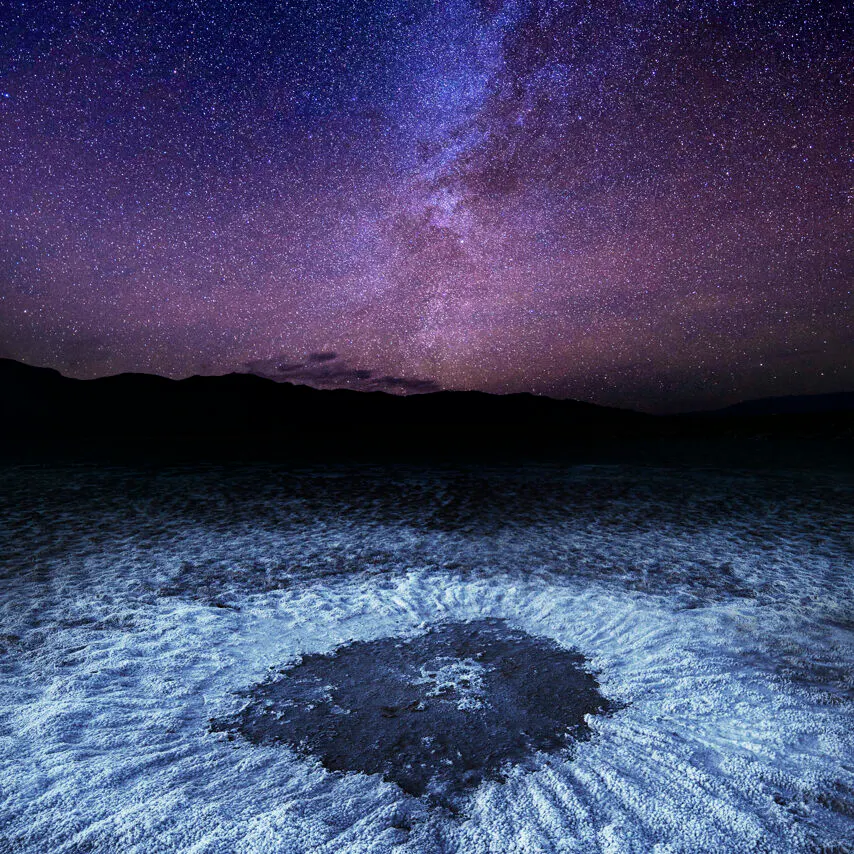 Death Valley National Park's salt flats lit up by the stars in the night sky - best national park for night viewing!