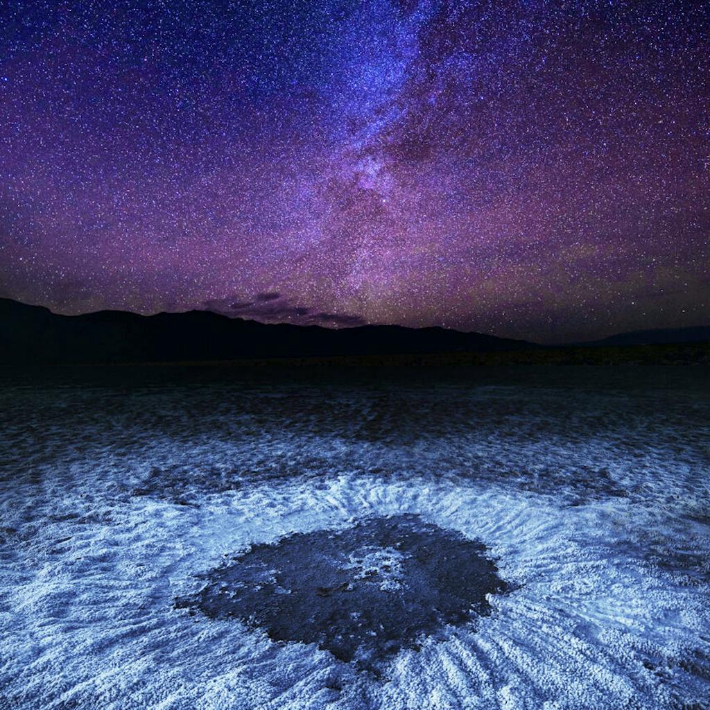 Death Valley National Park's salt flats lit up by the stars in the night sky - best national park for night viewing!