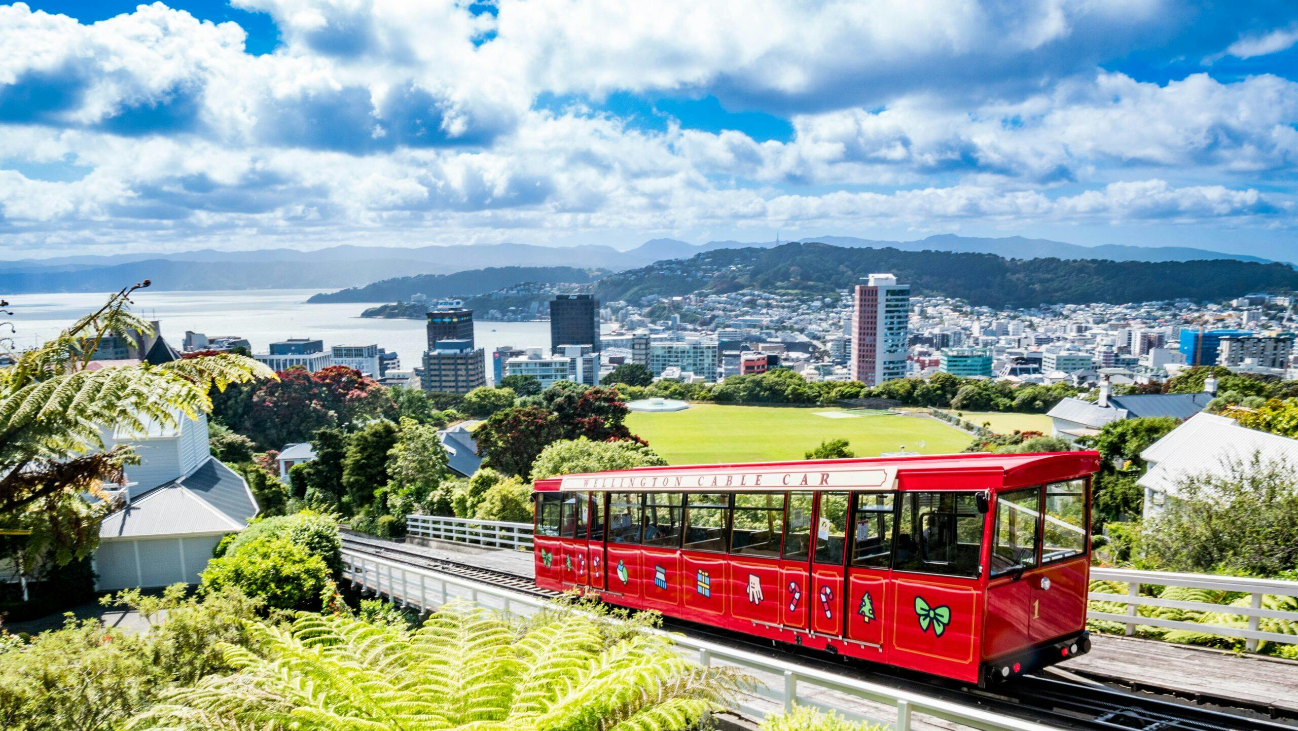 seeing a red trolley on a track with city of Wellington in the background in New Zealand, Europe
