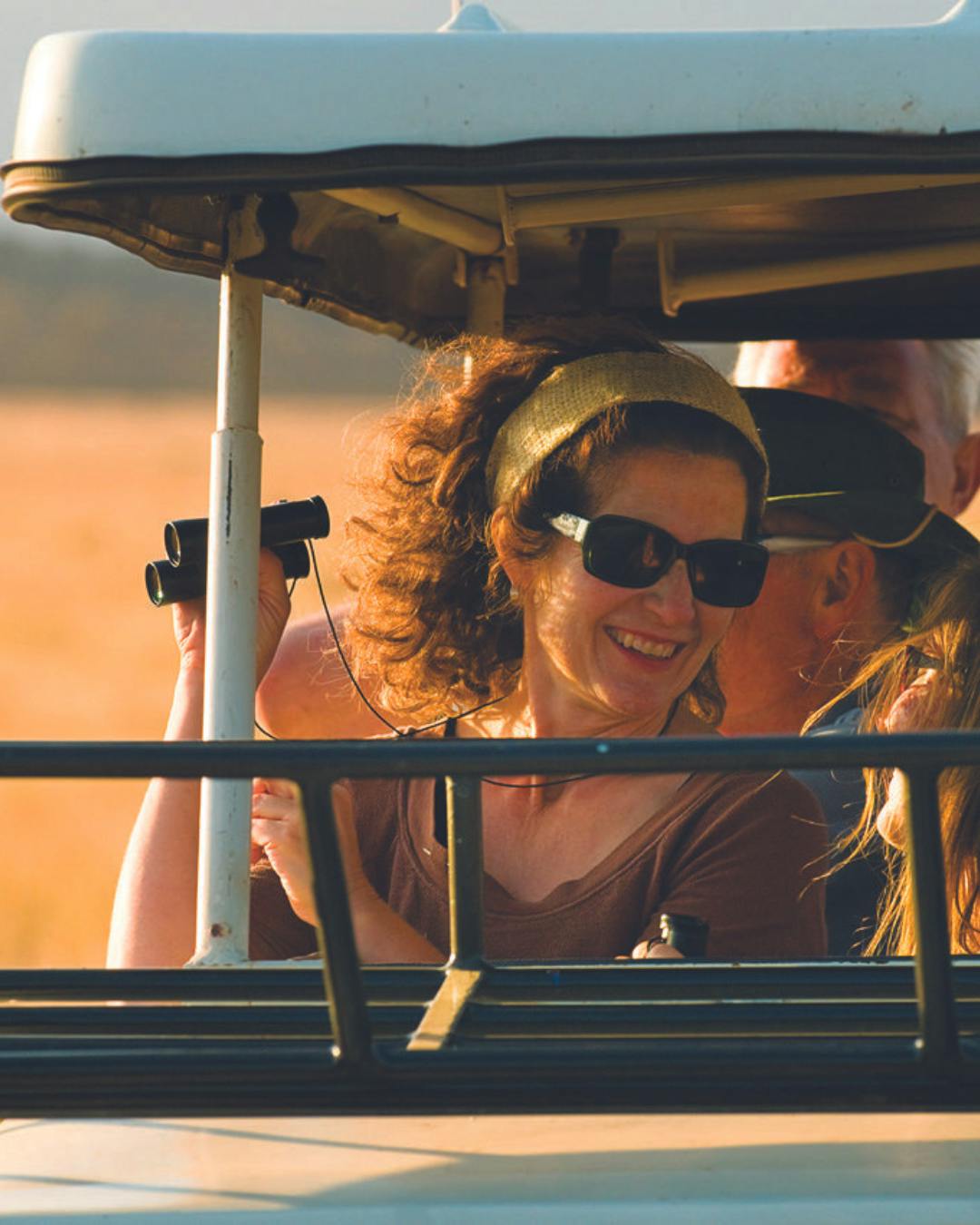 older traveler talking to passenger during morning game drive in safari in Tanzania, Africa
