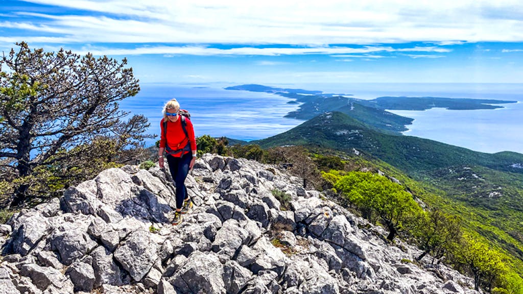 solo female hiker in red hiking rugged trails of the best Croatia hiking tour