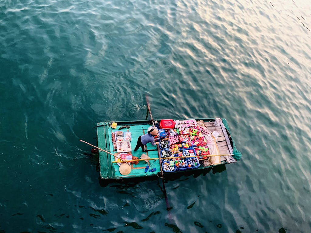 local villageperson assembling produce to sell for merchandise on boat in Vietnam, Asia