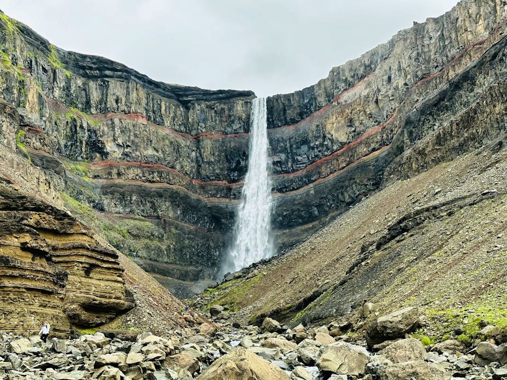 picturesque hike to Hengifoss Waterfall in gorge with copper-colored striations in Iceland, Europe