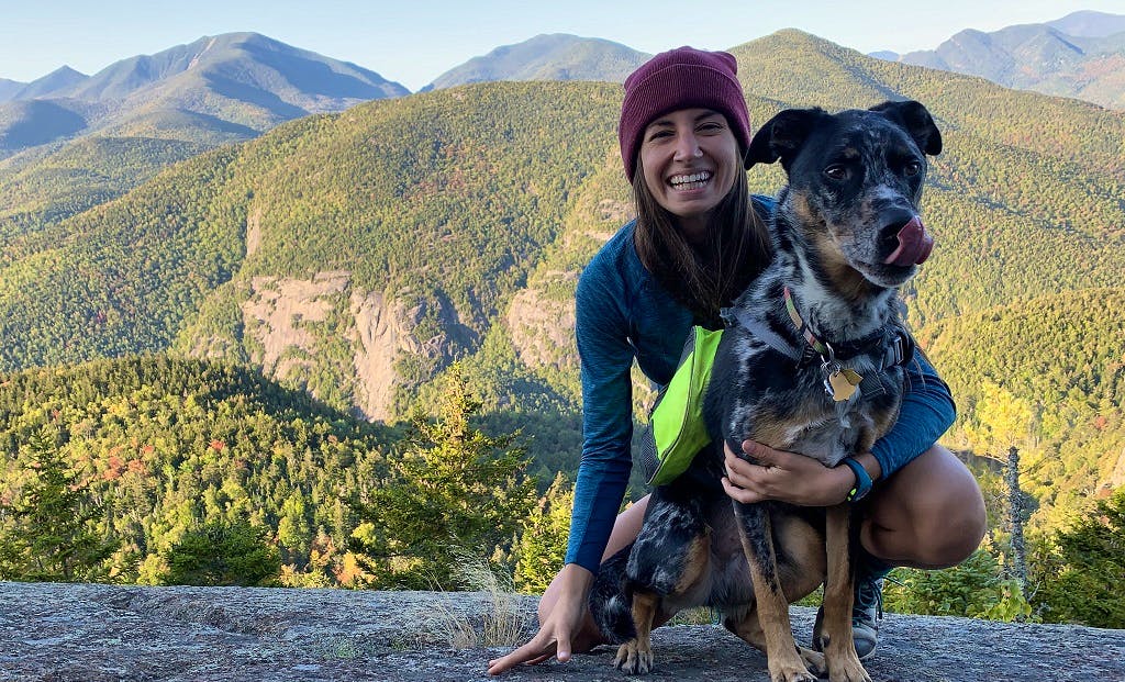 girl on a hiking trip with her black large dog in a national park in USA