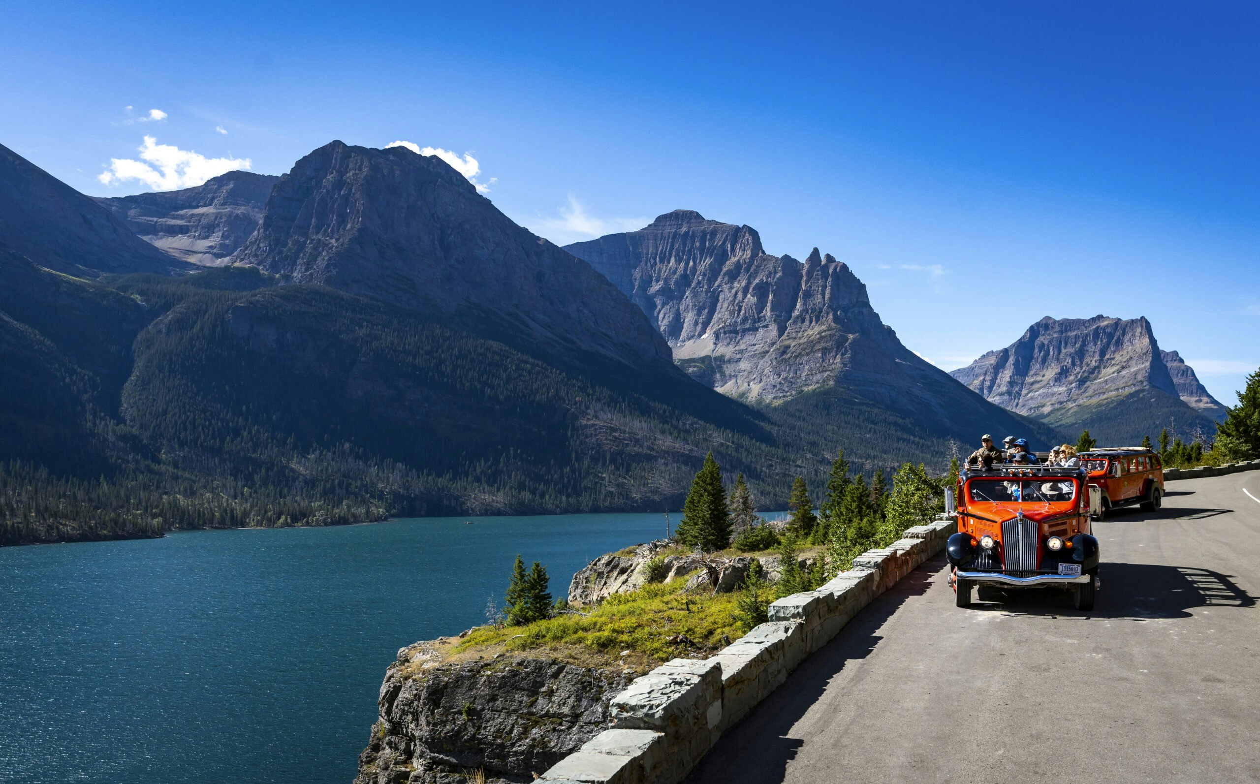 red bus driving in medicine road in Glacier National Park in Montana, USA