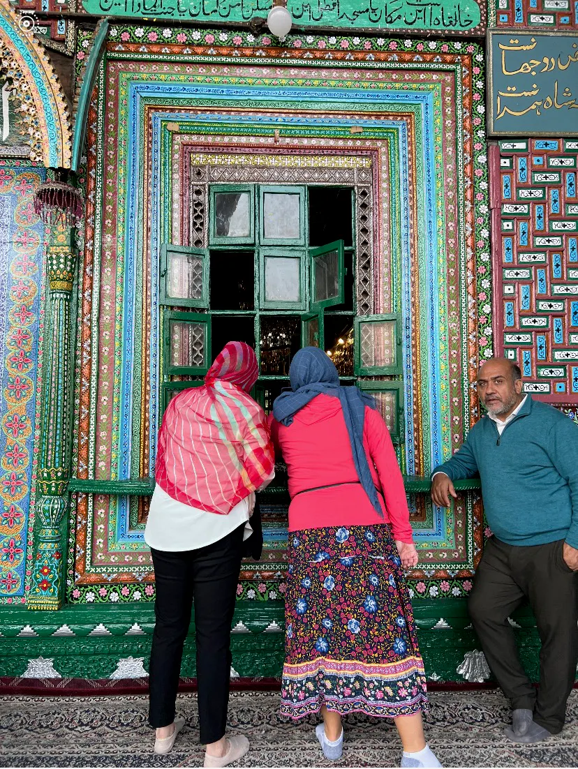mom and child looking into a window in downtown Kashmir during Secrets of Kashmir adventure in India, Asia