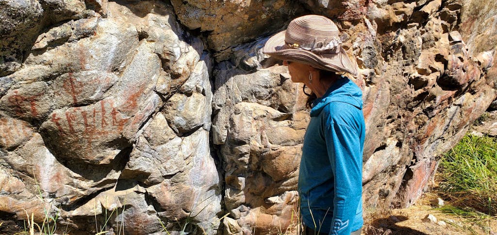 Woman looking at Sheepeater pictographs on the Middle Fork of the Salmon River with MT Sobek