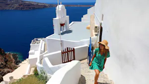 female traveler in green dress in Santorini near Aegan Sea in Greece, Europe
