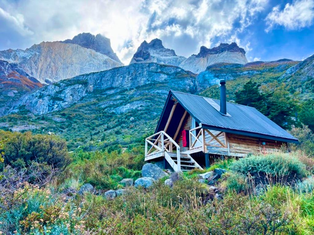 travelers staying overnight in cabins next to waterfall and Patagonian scenery in late fall in Patagonia