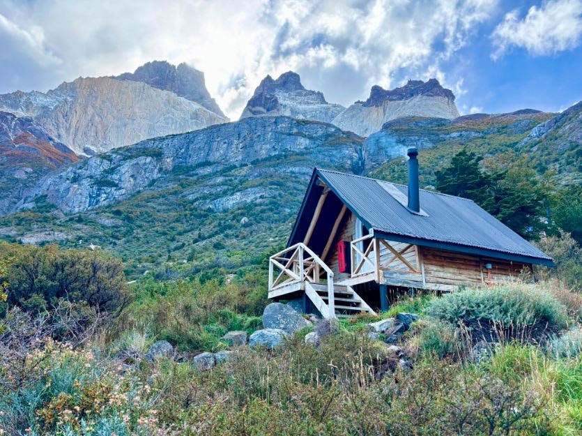 travelers staying overnight in cabins next to waterfall and Patagonian scenery in late fall in Patagonia