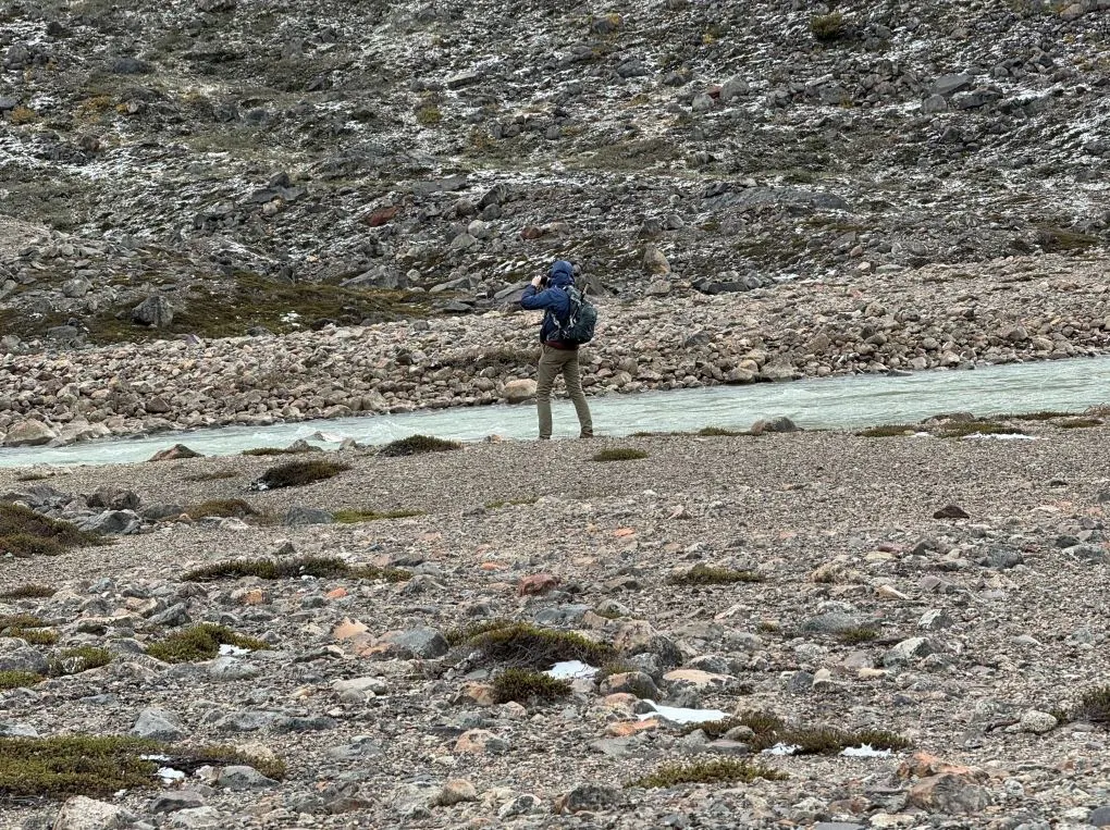 male traveler from Diane's group looking out with binoculars at Fritz Roy in Argentina during a hiking trip 