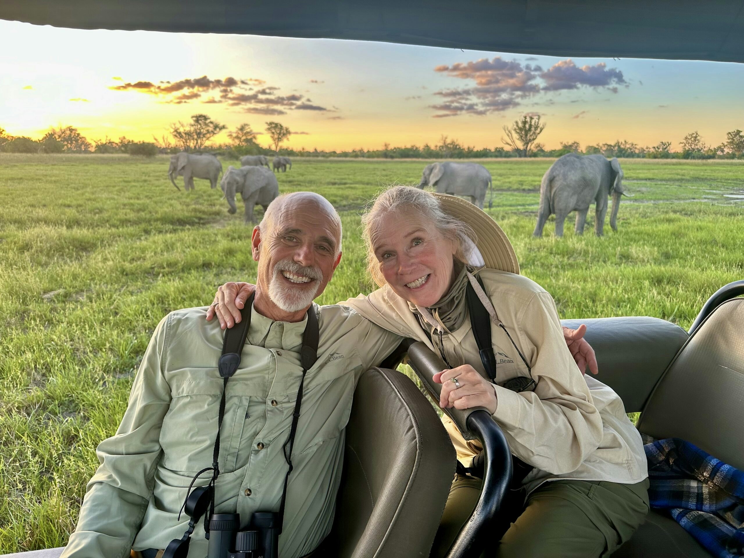 two happy travelers happy to be part of thrilling game drive in safari with elephants