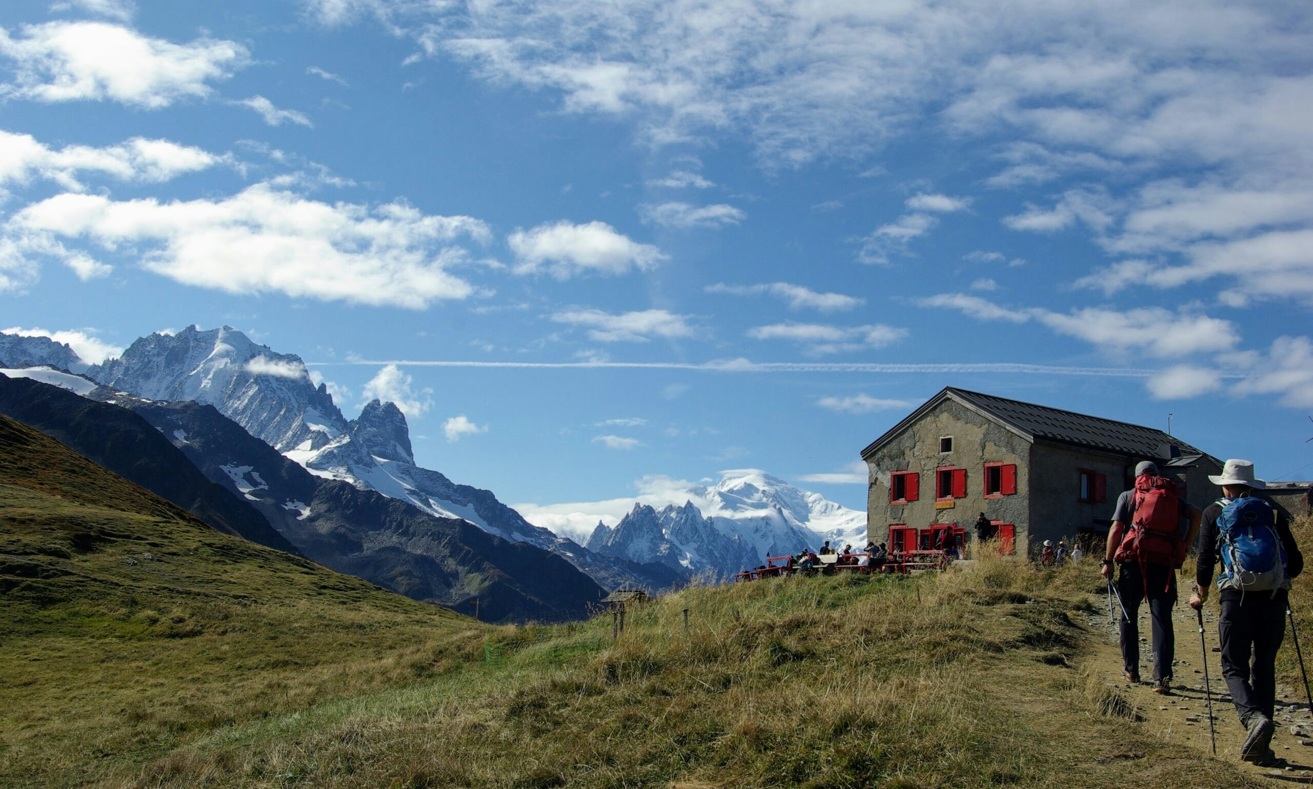 group of hikers on the Mont Blanc Express circuit loop hiking towards mountain lodge on hiking trail