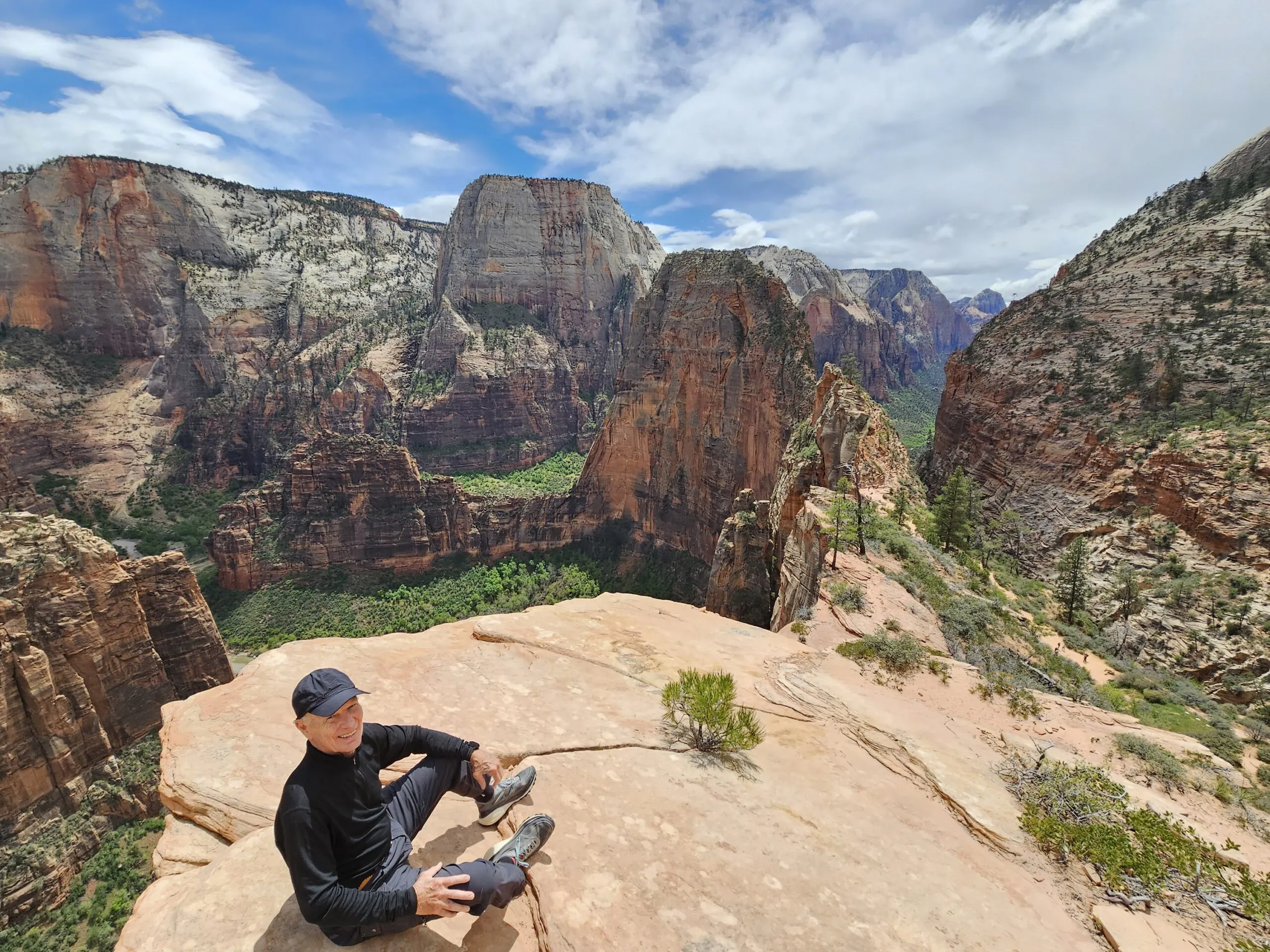 hiker sitting on rock with a view of valley in Utah National Park in North America
