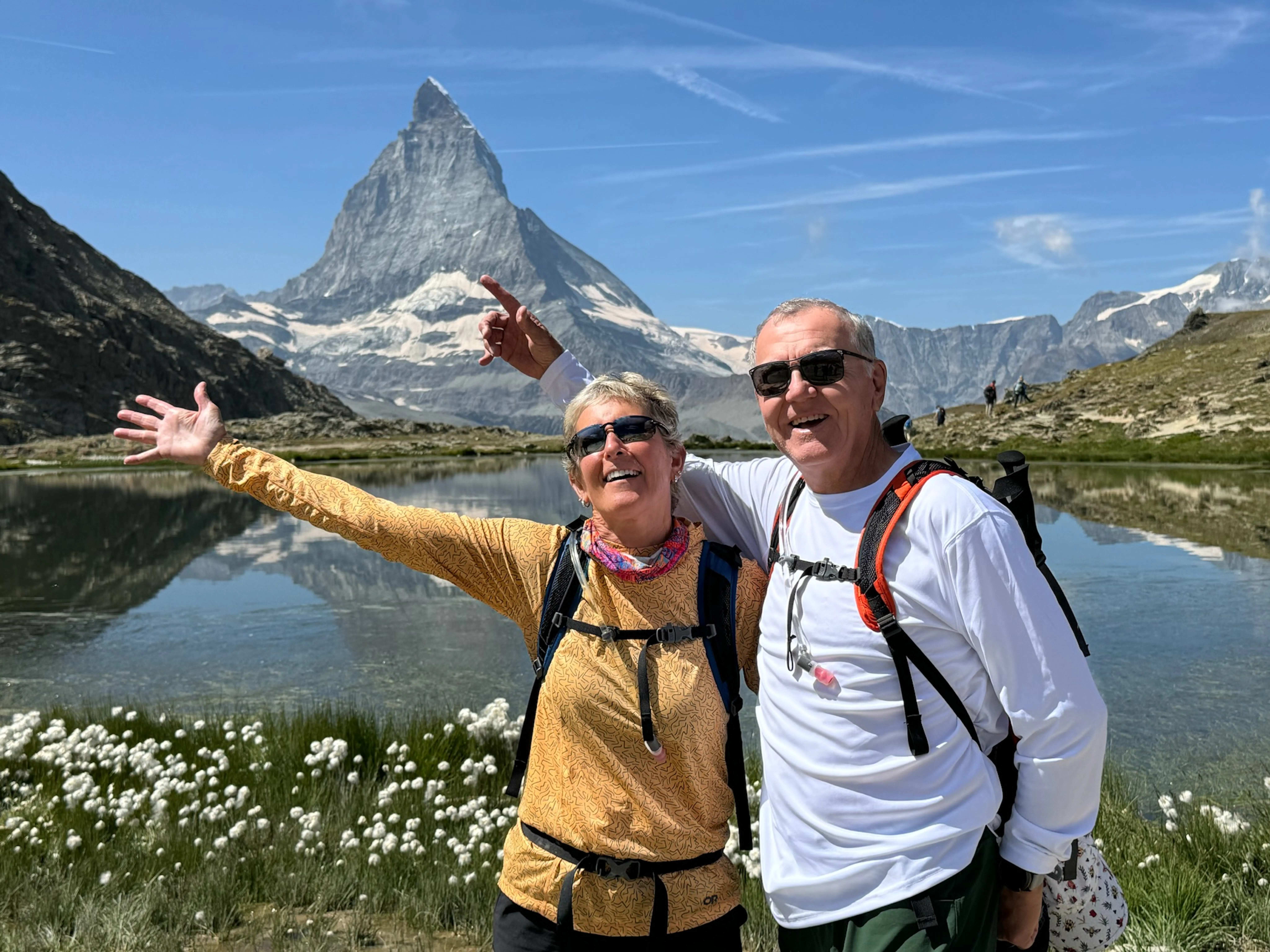 happy hikers a couple backpacking in Village to Village hiking tour in the Alps in summertime