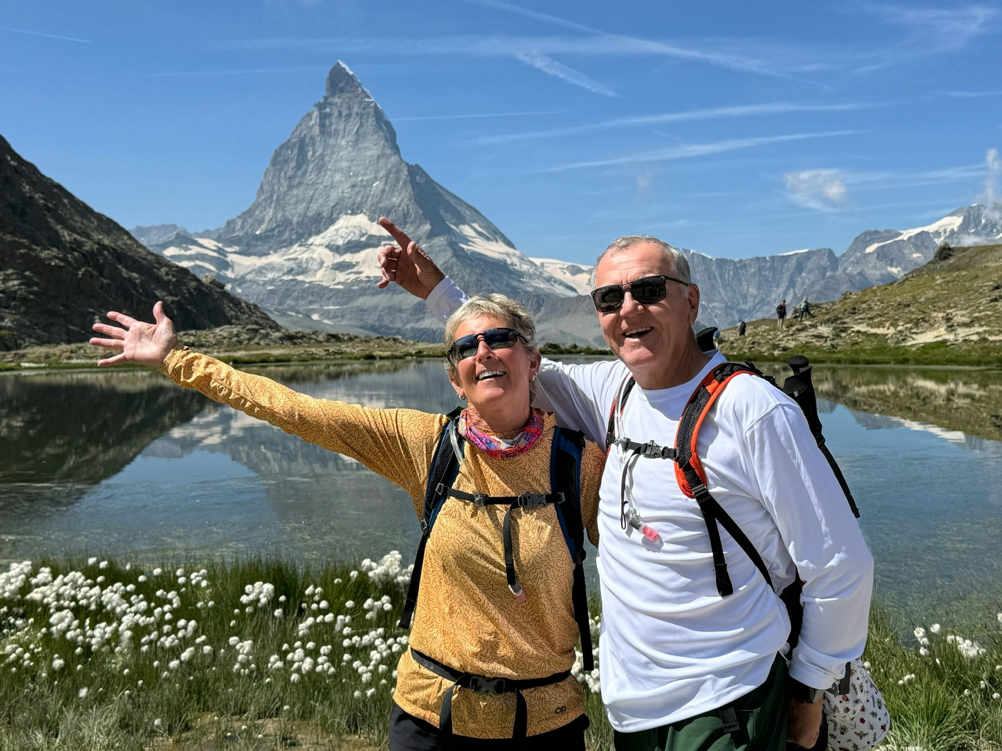 happy hikers a couple backpacking in Village to Village hiking tour in the Alps in summertime