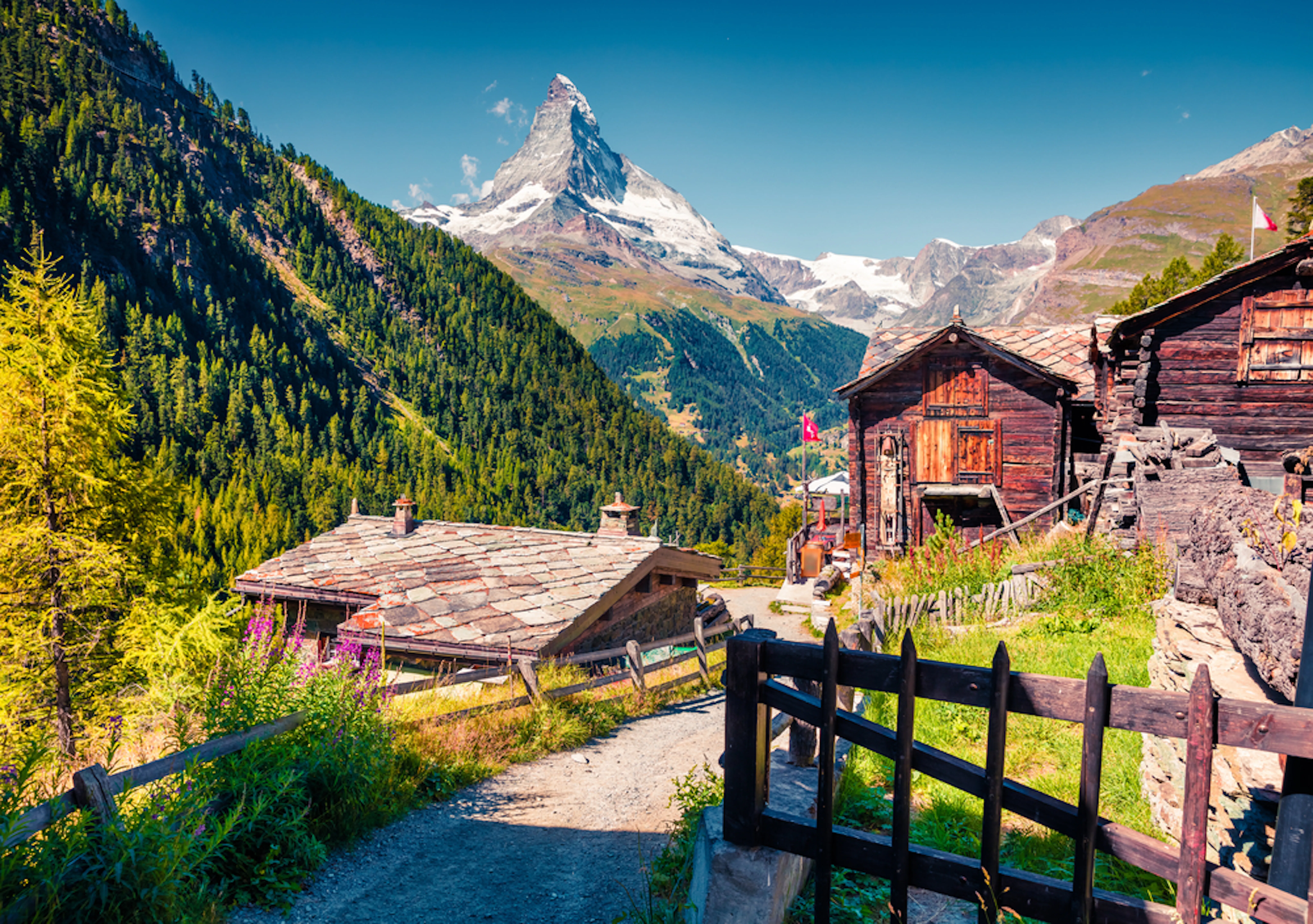 Sunny summer morning in Zermatt village with Matterhorn (Monte Cervino, Mont Cervin) peak on backgroud. Beautiful outdoor scene in Swiss Alps, Valais canton, Switzerland, Europe.
