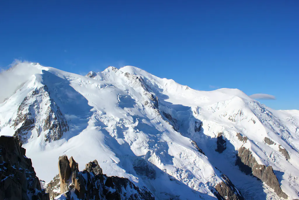 RectangleMt. Blanc (15,766') as seen from the Chamonix Valley on a clear sunny day with the rounded summit top in the center.  The Gouter ascent route begins from the right edge of the photo. 