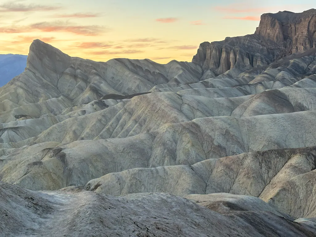 witness sunset views looking down from Zabriskie Point to Manly Beacon rock formation in Death Valley National Park in California
