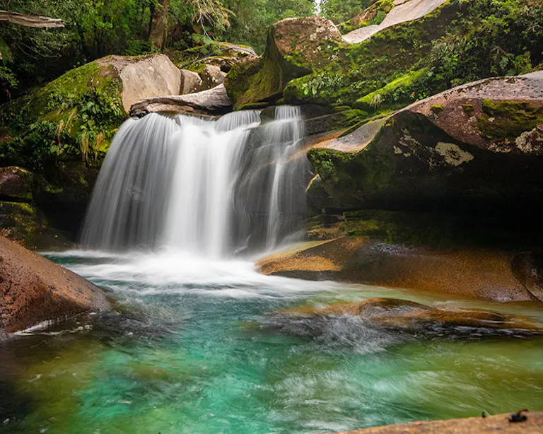 Pristine, glacial-fed creek in Cochamo Valley, Chile flowing over a cascade and into a turquoise pool