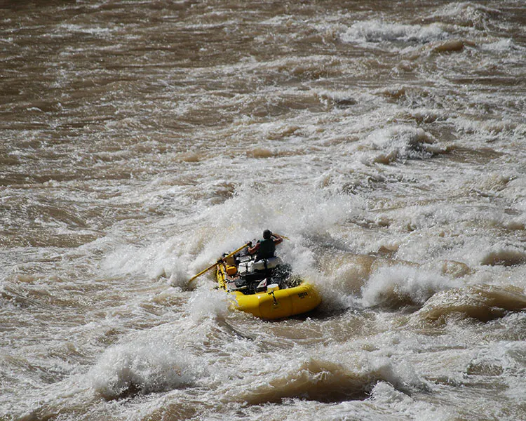 A raft crashing through intense rapids on the Colorado River in Grand Canyon National Park, Arizona