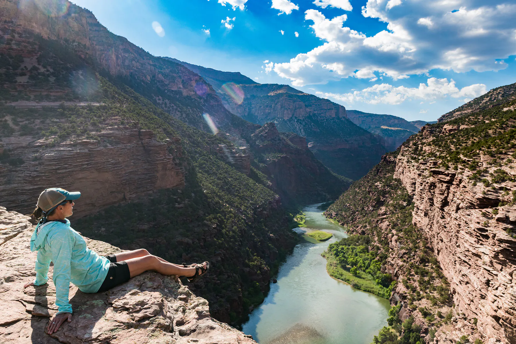 OARS guide sitting on a cliff looking down on the Green River in Dinosaur National Monument, Colorado