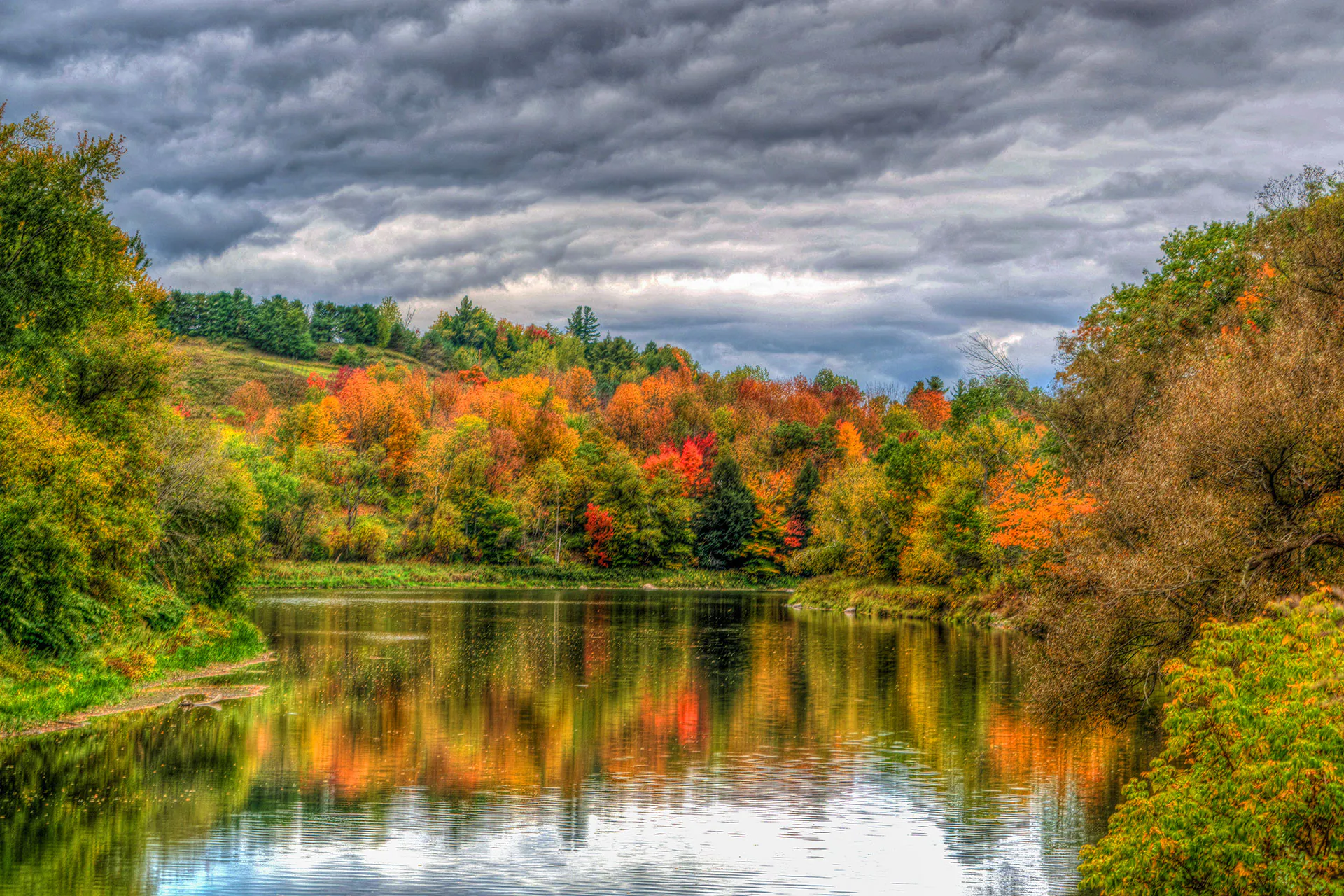 A glass-smooth pond on the East Coast surrounded by fall foliage