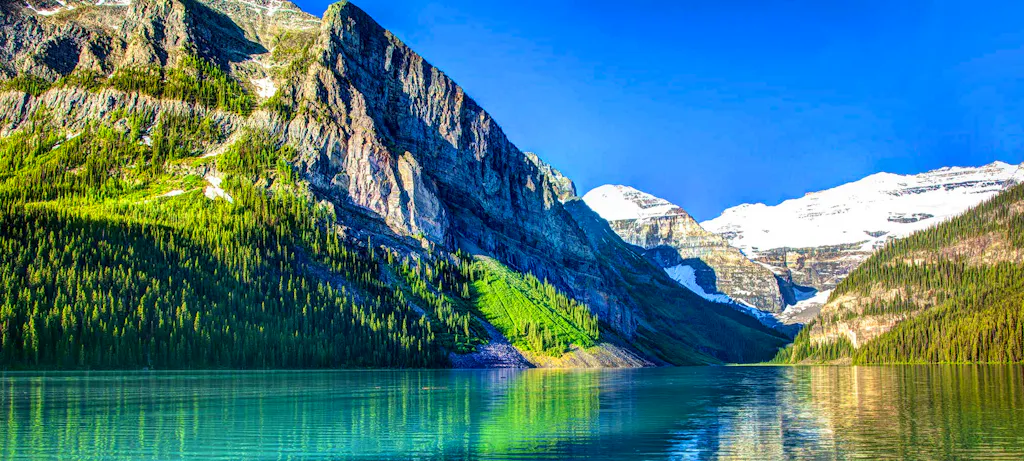 Stunning, turquoise alpine lake with glacier-covered mountains in the background in the Canadian Rockies