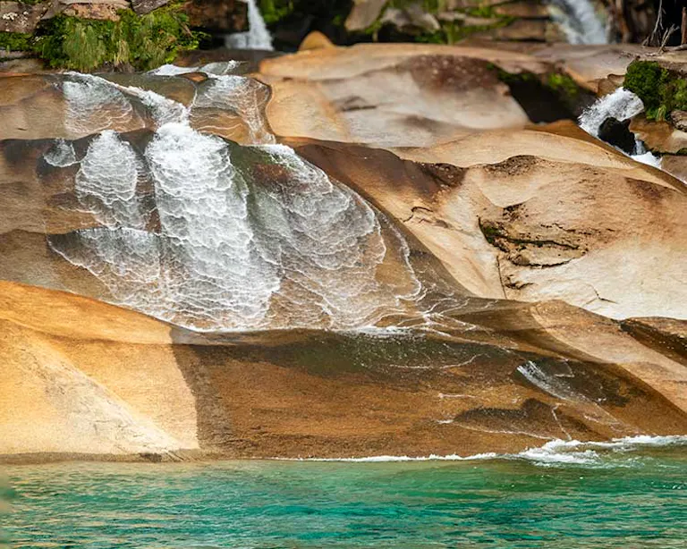 Stunning turquoise, glacial-fed water flowing over water-polished granite in Cochamo Valley, Chile