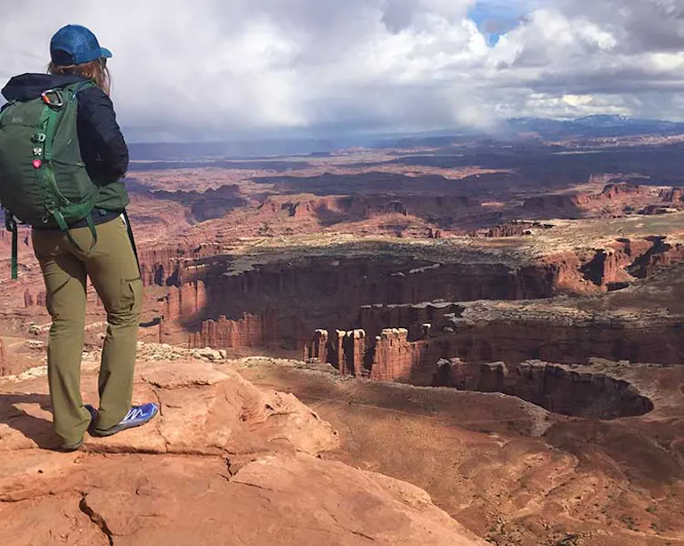 Woman standing at an overlook at Island in the Sky in Canyonlands National Park
