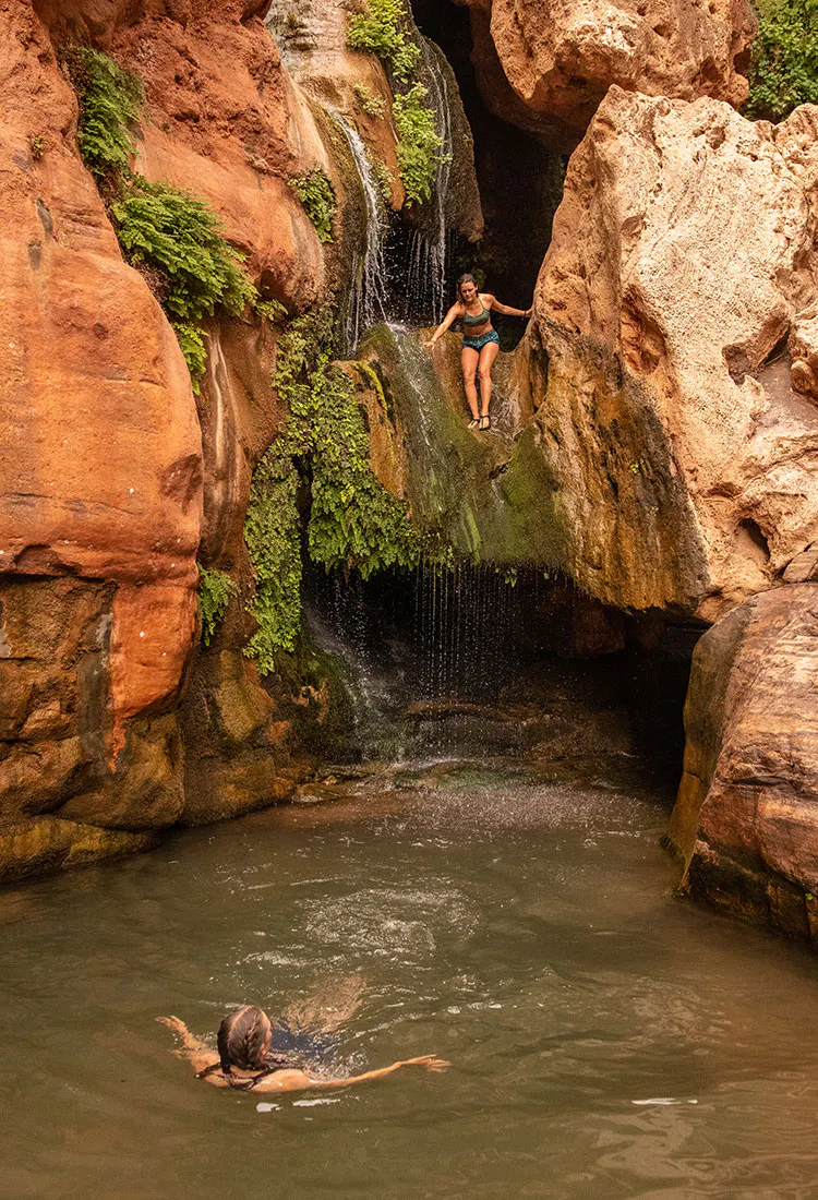 Two women swimming in Elves Chasm. One is about to jump from rocks above the pool. Grand Canyon National Park, Arizona