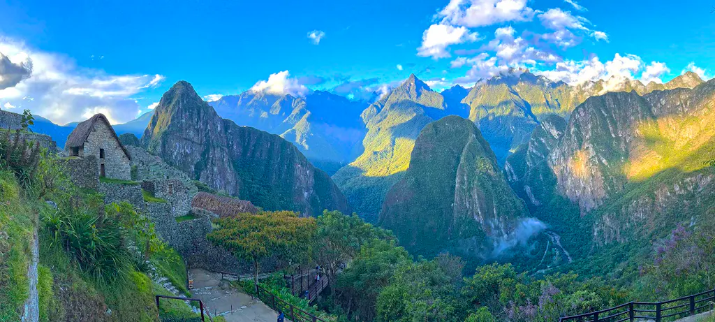 Inca Trail in Peru with historic, traditional stone building, forested mountains, drifting clouds